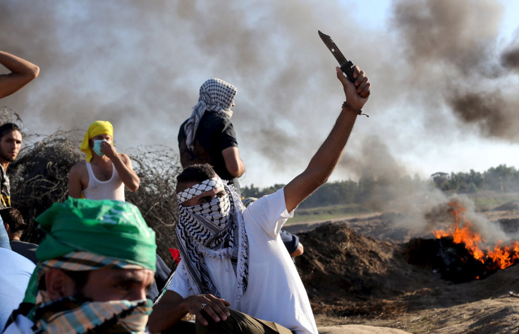 A Palestinian protester holds a knife during clashes.  