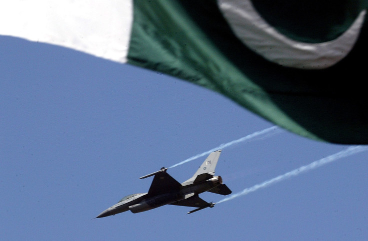 A Pakistani F-16 flies over the country's national flag. 