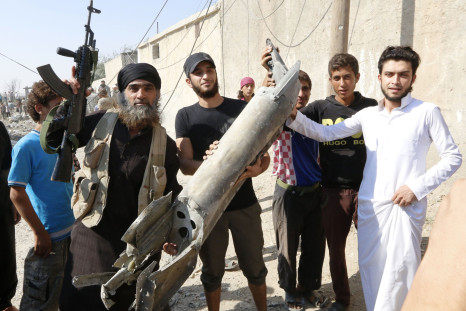 ISIS militants hold pieces of a Syrian jet near to Raqqa.