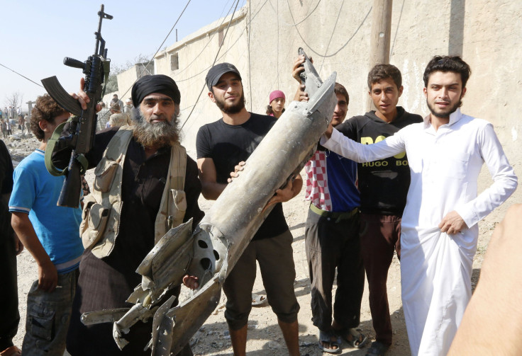 ISIS militants hold pieces of a Syrian jet near to Raqqa.