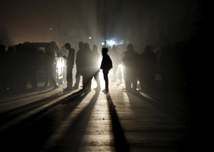 People stand in the aftermath of a bomb blast in Kabul, Afghanistan