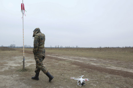 A drone rests as a Ukrainian soldier walks by. 