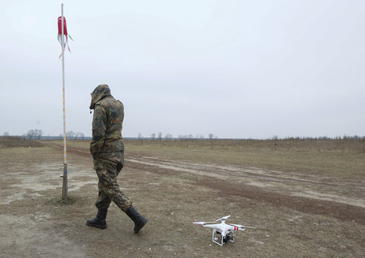 A drone rests as a Ukrainian soldier walks by.