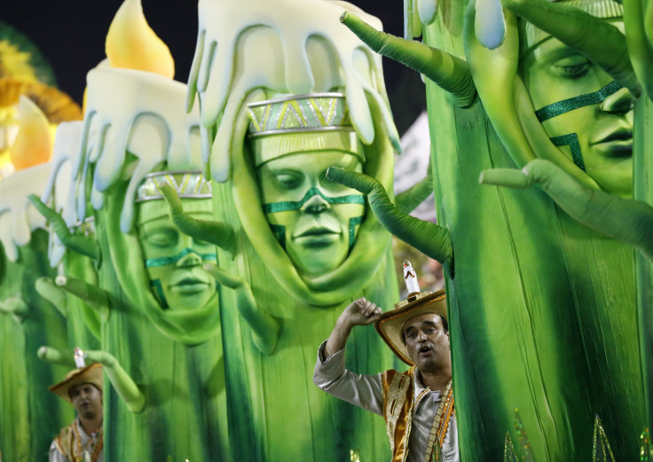 People in green statue-like costumes taking part in a Rio parade. 