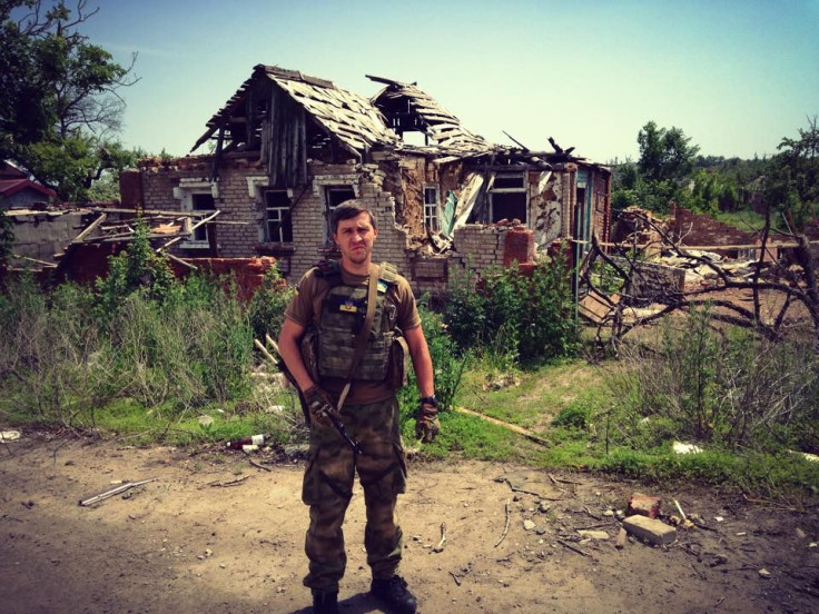 Ivan Rodichenko in front of a bombed out house in Donbass, Ukraine. 