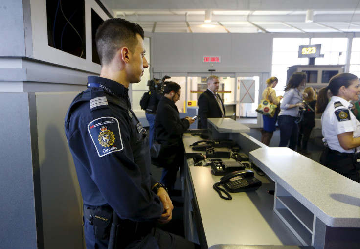 A Canadian border official watches over a terminal in Toronto.