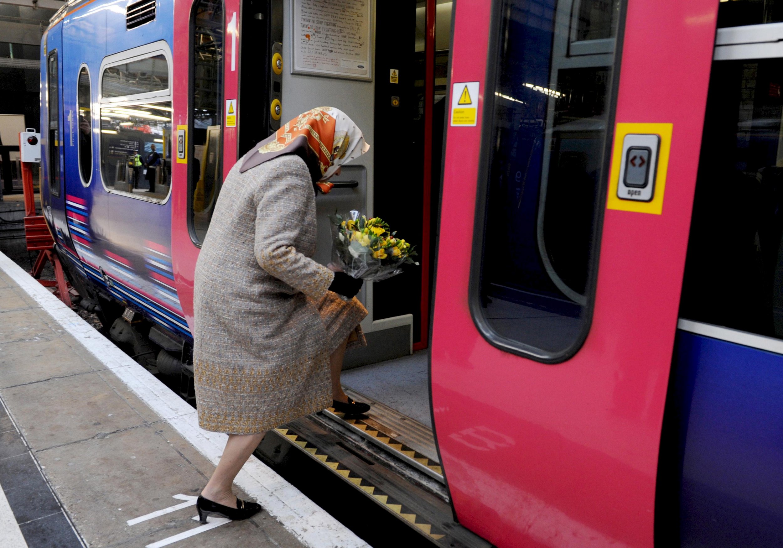 Britains Queen Elizabeth boards a train at Kings Cross station