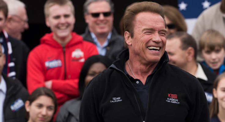 COLUMBUS, OH - MARCH 6: Former California Governor Arnold Schwarzenegger laughs while listening to Ohio Governor John Kasich speak to a crowd during a campaign rally at the Wells Barns at the Franklin Park Conservatory on March 6, 2016 in Columbus, Ohio.