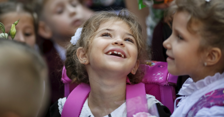 A first grader smiles as she attends a ceremony to mark the start of another school year in Kiev, Ukraine, September 1, 2015. 