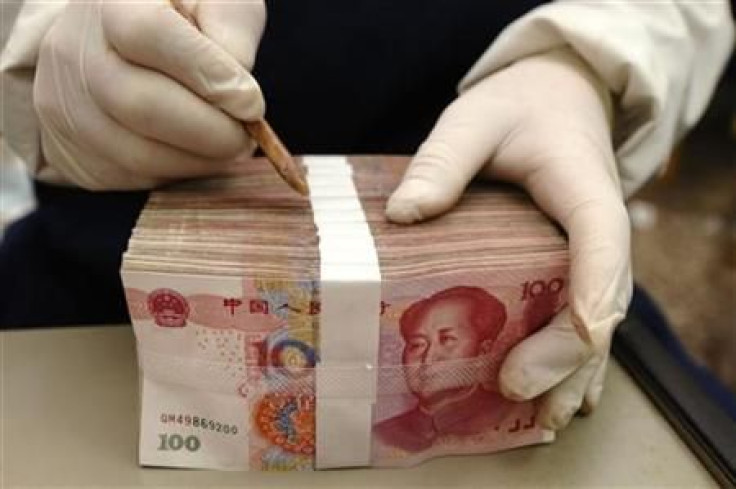 An employee packs yuan banknotes at a branch of Bank of China in Changzhi