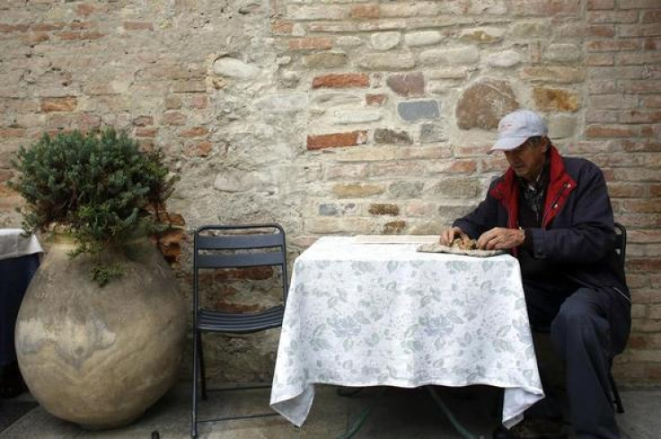 Truffle hunter Ezio Costa, 66, inspects a truffle as he sits outside his restaurant in Monchiero near Alba northwestern Italy, November 9, 2013. REUTERS-Stefano Rellandini