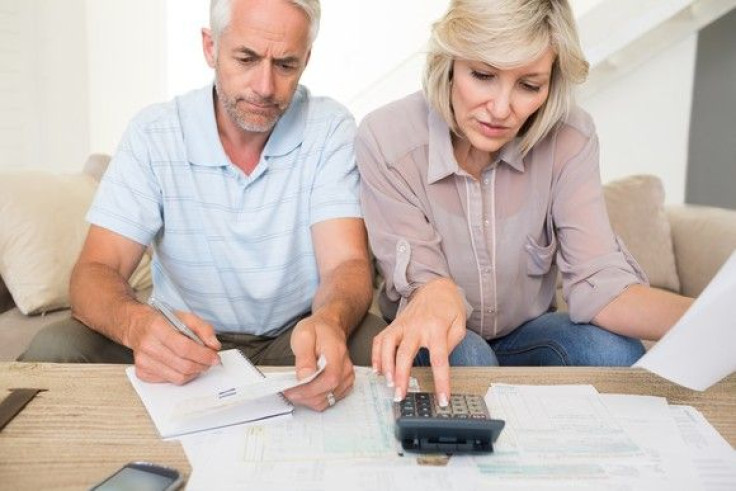 mature-couple-looking-at-documents-and-using-calculator-bills-finances_large