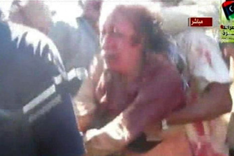 Former Libyan leader Muammar Gaddafi, covered in blood