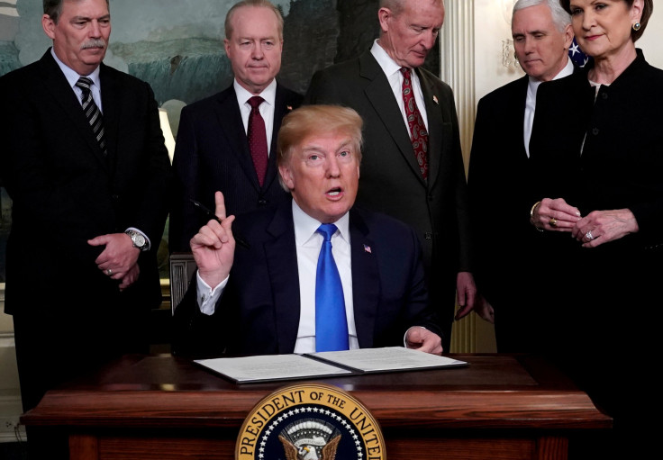 President Donald Trump surrounded by business leaders and administration officials