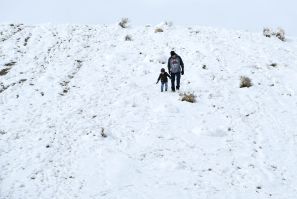 Parent and child walk through snow in Vegas