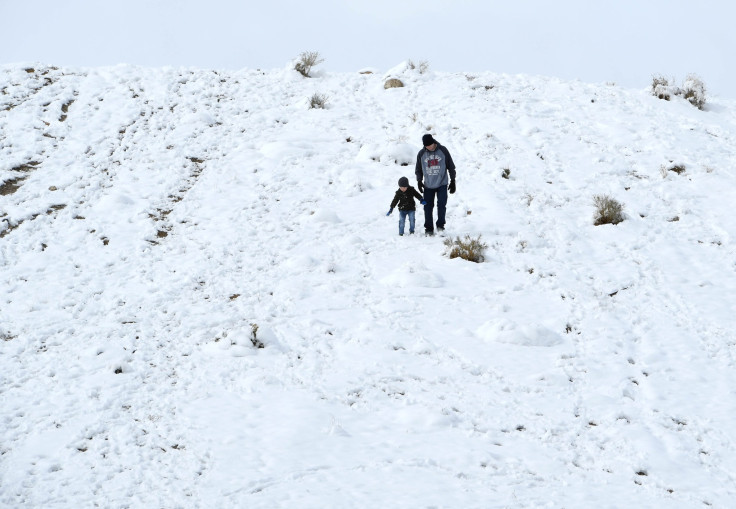 Parent and child walk through snow in Vegas