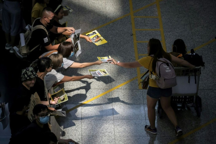 Protesters have swarmed the Hong Kong airport arrivals hall, offering leaflets to incoming travellers with information about the unrest that has gripped the territory