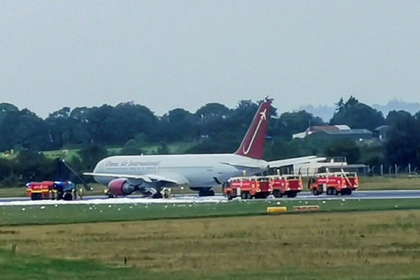 Firecrews attend an Omni Air International aircraft on the tarmac at Shannon Airport in County Clare, western Ireland, after a fire broke out on the undercarriage of the plane on the runway