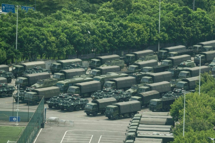 Military trucks and armored personnel carriers outside the Shenzhen Bay stadium in Shenzhen, bordering Hong Kong