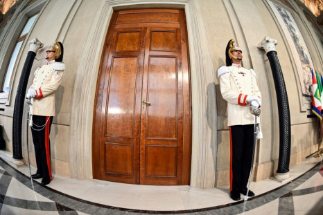 Italian elite military presidential officers stand guard outside the Quirinal palace in Rome as President Sergio Mattarella holds consultations