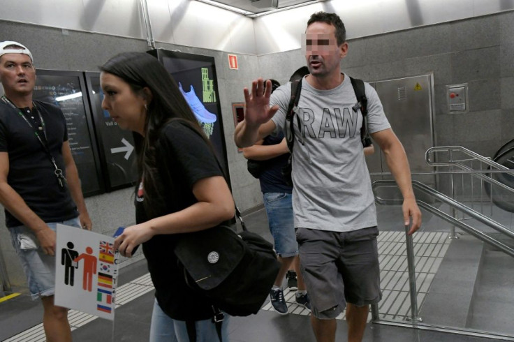 A plainclothes police officer (R) tells citizens on patrol, who warn metro passengers of pickpockets, that their action hampers police work