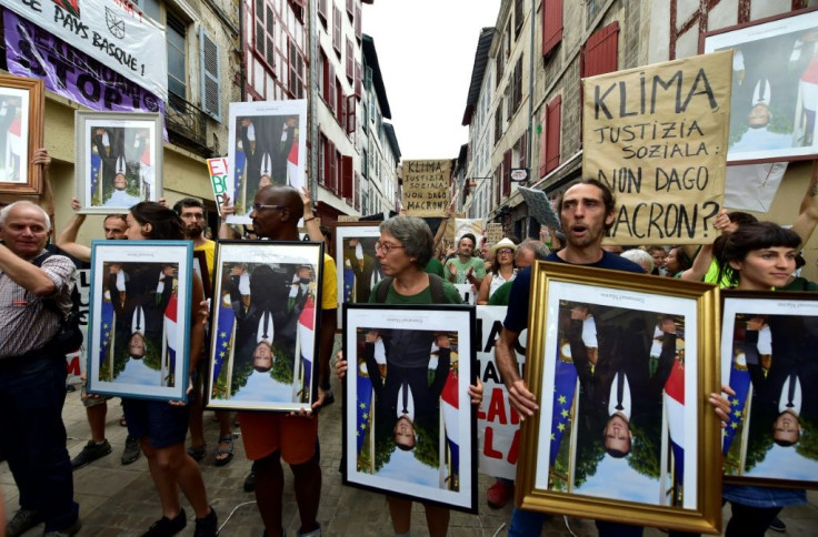 "Take down Macron!" the protesters shouted, holding the portraits upside down to reflect how they see his policies