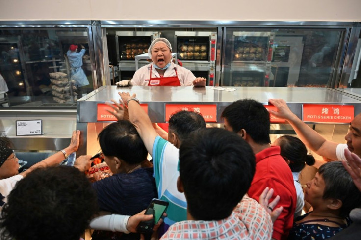 Bargain-hunters battled to get their hands on freshly cooked rotisserie chickens while staff pleaded with them to form a queue