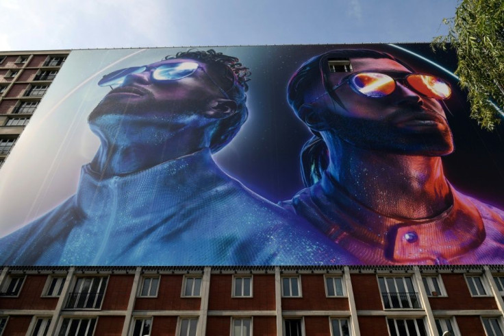 A giant banner depicting the two brothers Ademos and N.O.S (real names Tarik and Nabil Andrieu) of the French rap group PNL (Peace N' Loves). They spent part of their childhood in the Gagarine housing estate