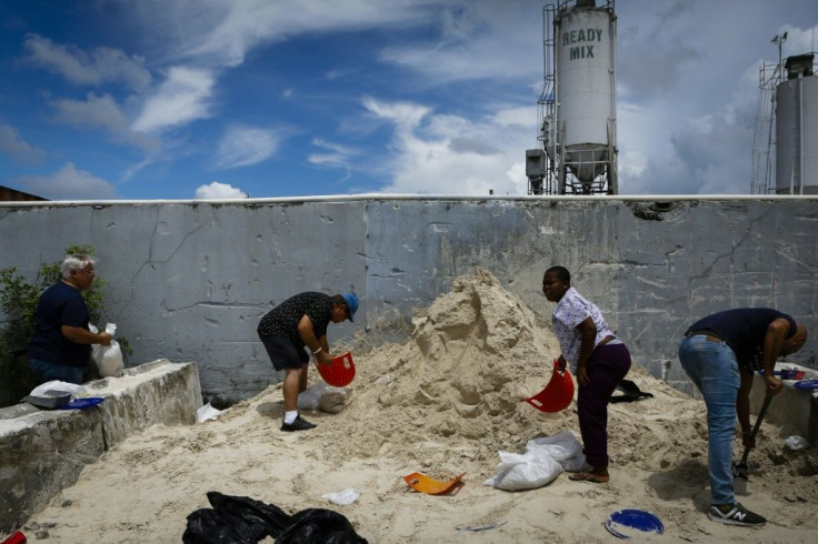 People fill sandbags donated by a ready-mix company to Miami-Dade residents preparing for Hurricane Dorian in West Miami