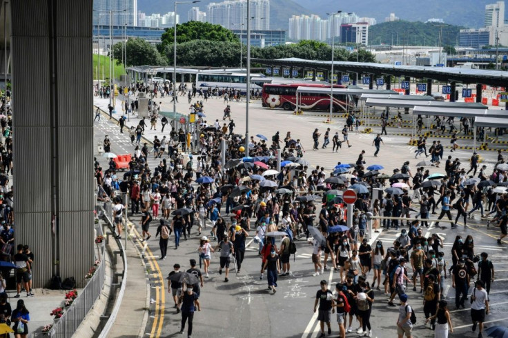 Protesters run from police at the bus terminal at Hong Kong's airport