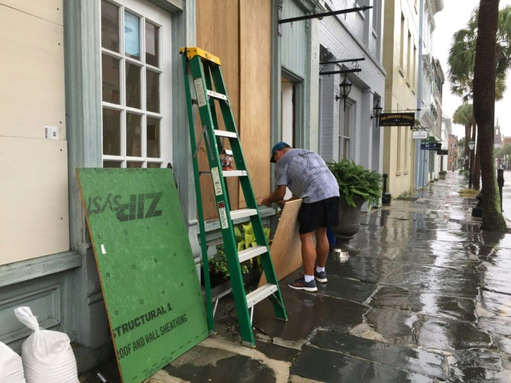 A man boards up a jewelry store on Broad Street in Charleston, South Carolina, a city that is feeling the economic bite of Hurricane Dorian