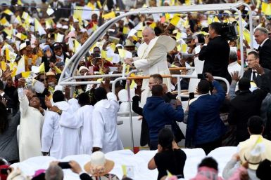 Many of the faithful wore pope-emblazoned white and yellow caps -- the colours of the Vatican, and cheered as the pope-mobile made its way through wind-swept clouds of red dust