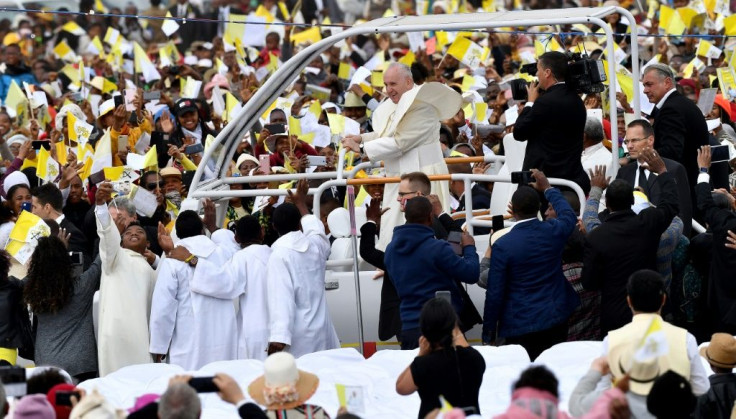 Many of the faithful wore pope-emblazoned white and yellow caps -- the colours of the Vatican, and cheered as the pope-mobile made its way through wind-swept clouds of red dust
