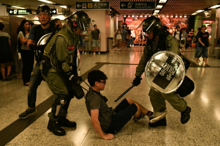 A suspected protester is detained by police inside Hong Kong's Causeway Bay MTR metro underground station, where officers fired tear gas outside