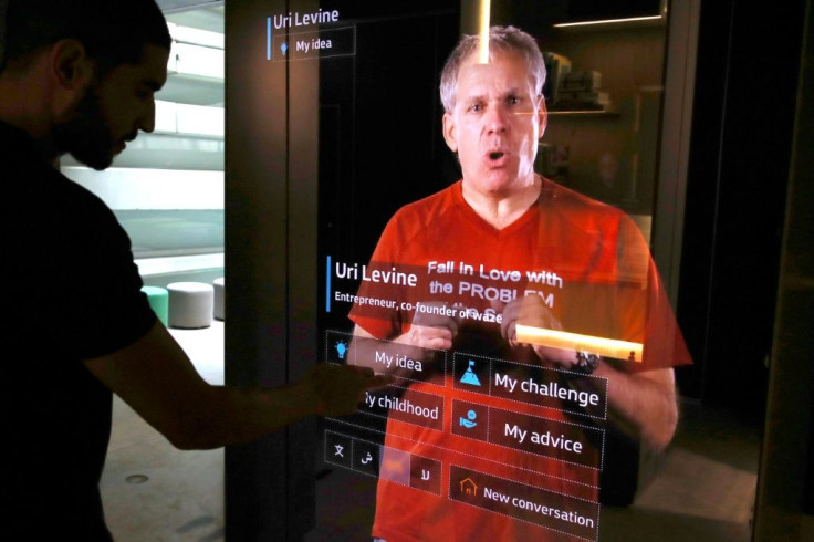 The Israeli co-founder of the navigation app Waze appears on a life-sized screen with words of advice on his t-shirt: 'Fall in love with the problem not the solution'