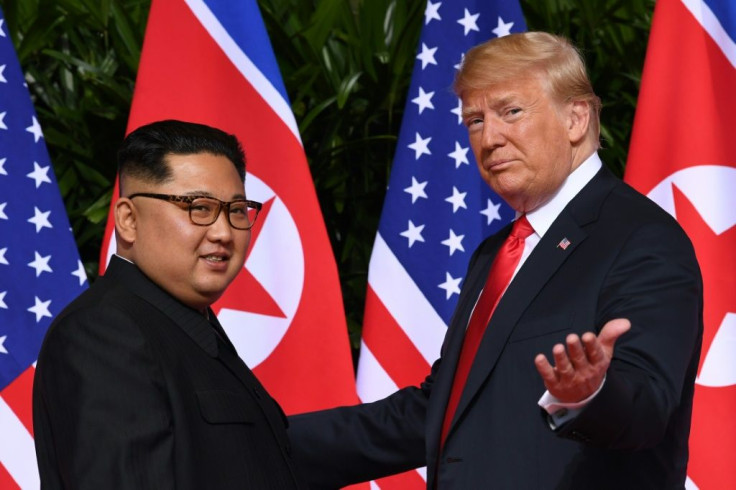 (FILES) In this file photo taken on June 12, 2018 US President Donald Trump (R) meets with North Korea's leader Kim Jong Un (L) on Sentosa Island in Singapore. The US has slapped sanctions on three North Korea government-sponsored hacking operations