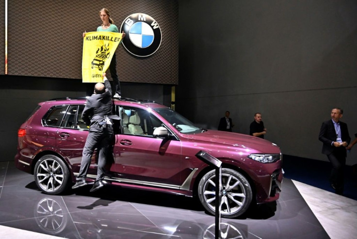A Greenpeace activist protested at the Frankfort motor show earlier this week by standing on top of a SUV on display with a poster that read 'Climate Killers'