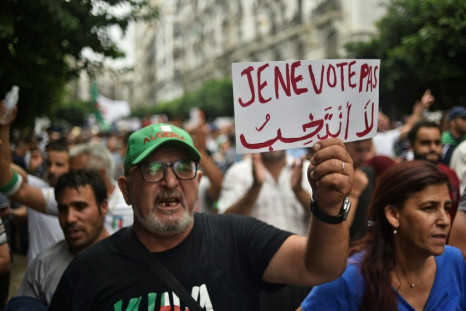 An Algerian protester holds a placard reading "I won't vote" during a demonstration against the ruling class in the capital Algiers on September 13, 2019, for the 30th consecutive Friday since the movement began