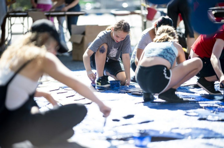 Nora Gell (center), 14, paints cardboard waves in Brooklyn on September 15, 2019 for the climate strike protests planned for September 20