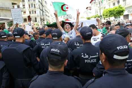Algerian protesters face riot police during a demonstration in the capital Algiers in June