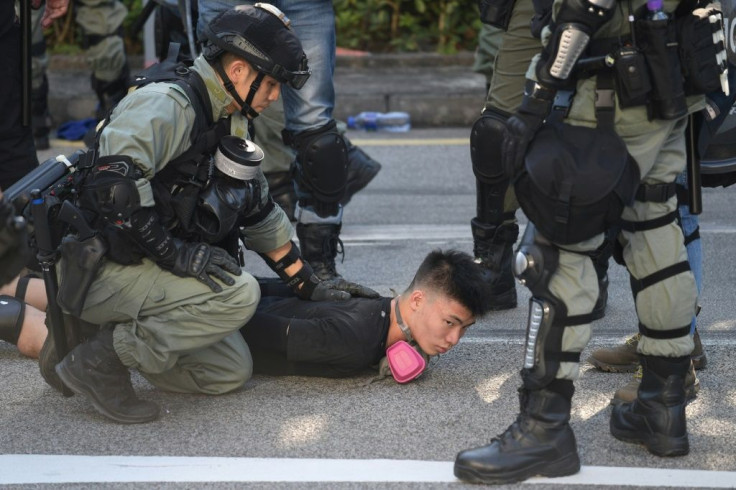 Police detain a demonstrator during protests in Hong Kong's Tuen Mun district