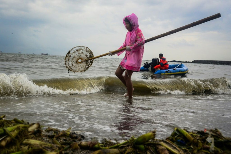 Volunteers in Manila scoop up coastal trash as part of the World Cleanup Day initiative