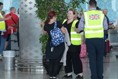 British officials talk to tourists booked with Thomas Cook as they wait for repatriation flights from Enfidha airport on the outskirts of the Tunisian coastal resort of Sousse