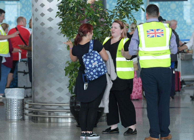 British officials talk to tourists booked with Thomas Cook as they wait for repatriation flights from Enfidha airport on the outskirts of the Tunisian coastal resort of Sousse