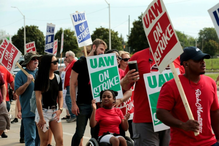 Moriha Ross, a member of the United Auto Workers, pushed her daughter Rhian on Sunday as they picketed outside of GM's Detroit-Hamtramck Assembly in Detroit