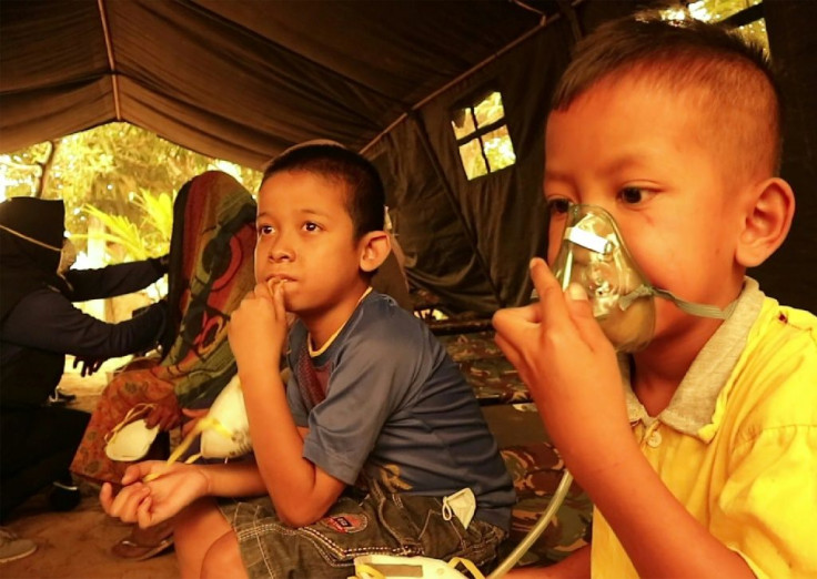 Indonesian children get a dose of oxygen from a Red Cross volunteer. UNICEF says the forest fires are puttling nearly 10 million children at risk from the toxic air