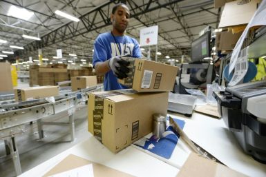 Waning consumer confidence could hit retail sales, a mainstay of the US economy. Employee Lamar Roby prepares shipping orders at Amazon's San Bernardino Fulfillment Center