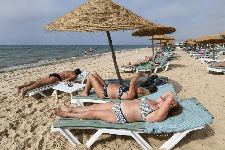 Tourists sunbathe on a private beach near a hotel in Tunisia's Nabeul on July 1, 2018