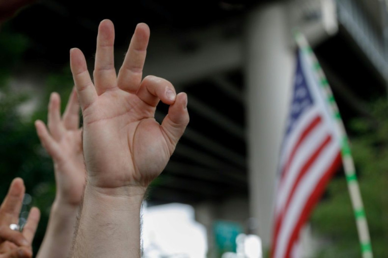 A far-right demonstrator makes the OK hand gesture at a rally in Portland, Oregon in August 2019 -- some say the simple signal has white supremacist overtones, but the Anti-Defamation League says far-right sympathizers use it to troll the left