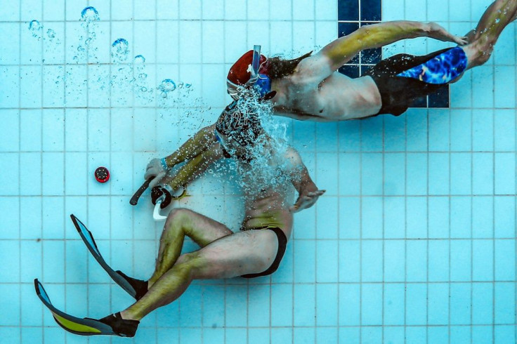 Players fight for the puck during an underwater hockey training session